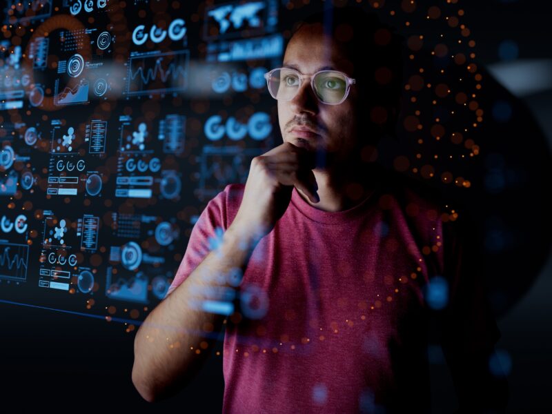 Man looking at virtual board displaying blue computer code