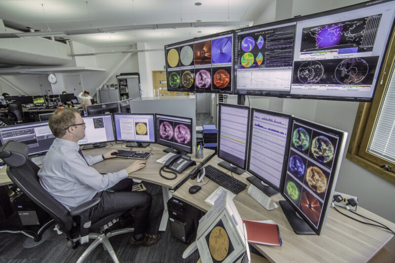 Man looking at multiple screens showing different views of hte sun for monitoring space weather