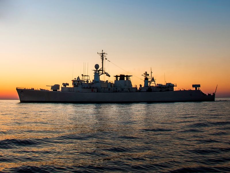Naval ship at sea with an orange sunset