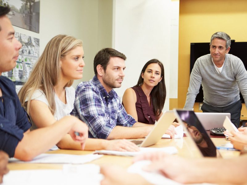team of men and women talking around a table