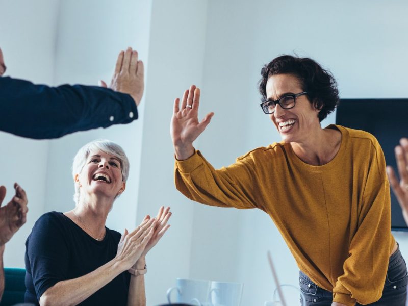 Team of people doing a high five and clapping